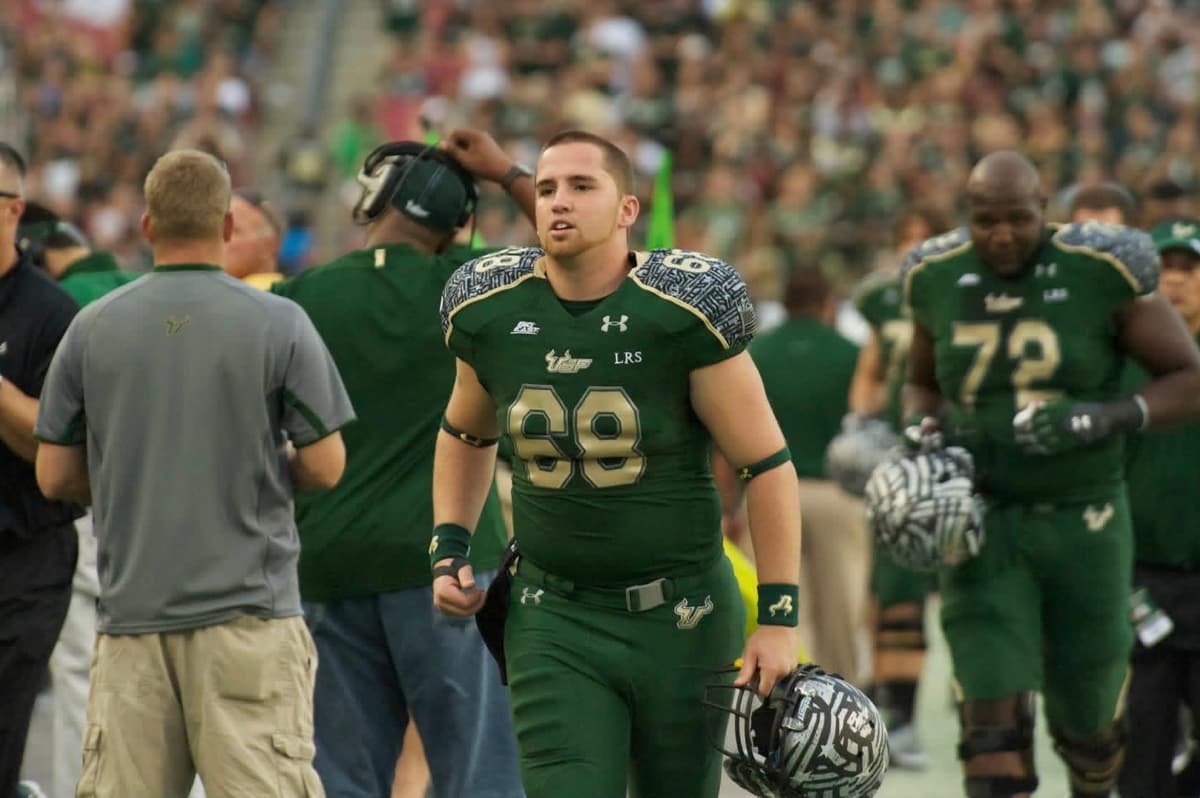 Mike Walsh on the sideline at USF, helmet in hand