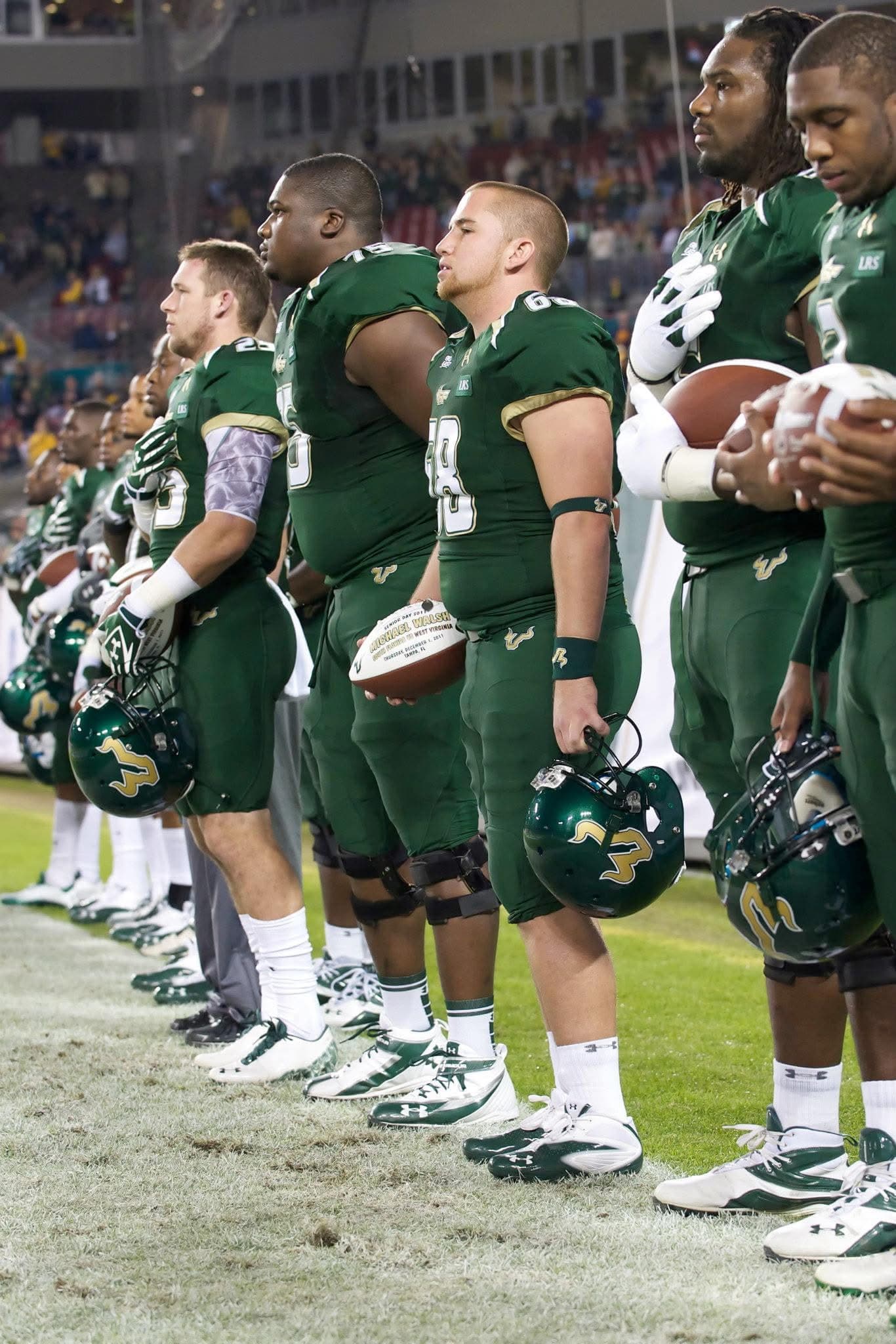 Mike Walsh lined up with teammates on Senior Night, holding commemorative ball
